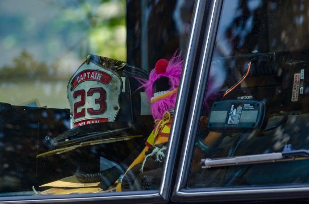 The Muppet, Animal, takes a ride on a firetruck