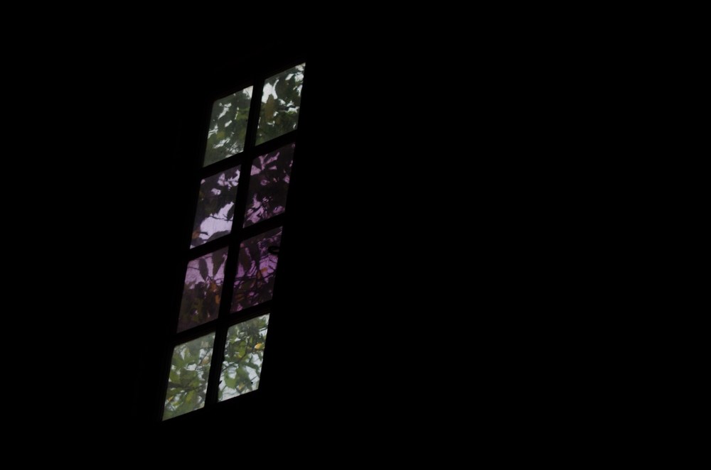 A window in the rafters, surrounded by darkness.