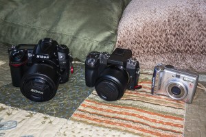 Nikon D7000, Panasonic Lumix G7, and an older Canon Power Shot point and shoot.