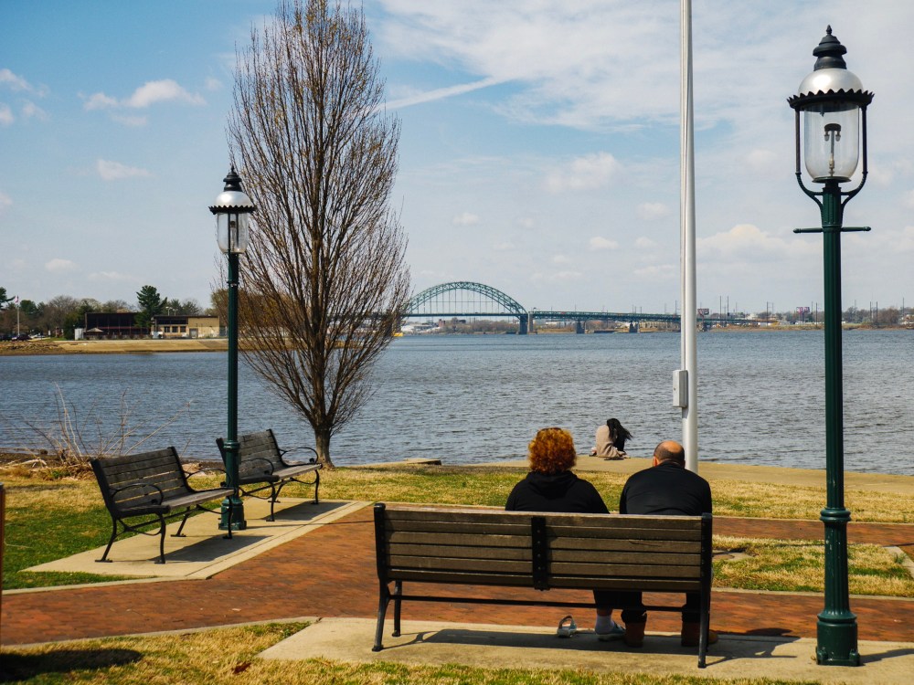 Three people form a triangle as they gaze upon the river.
